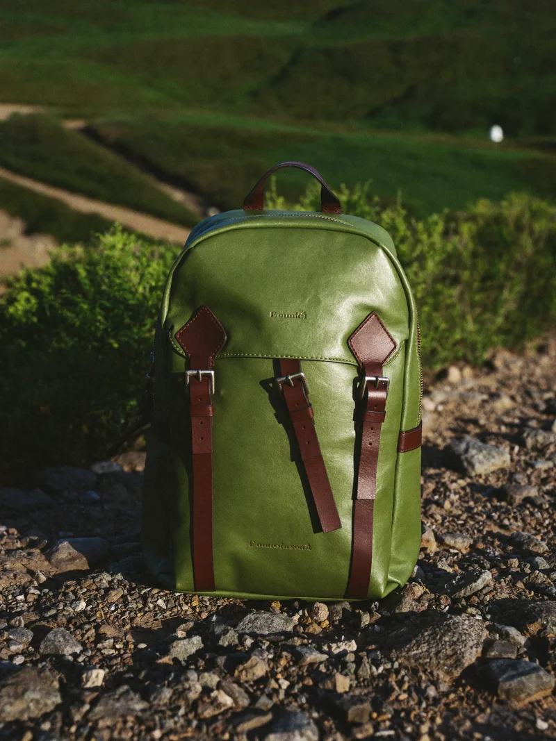 Kompakter Tagesrucksack aus gewachstem Canvas mit Lederriemen am felsigen Wegrand